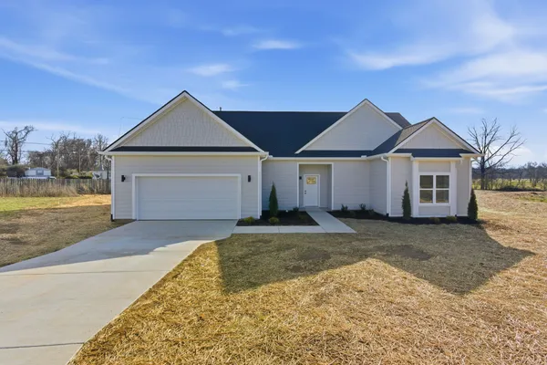 a front view of a house with a yard and garage