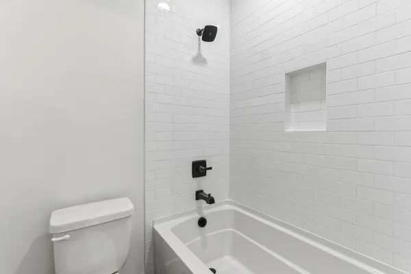 a bathroom with a bathtub a toilet and a shower