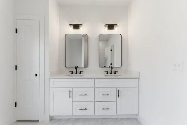 a bathroom with double vanity sinks and a mirror