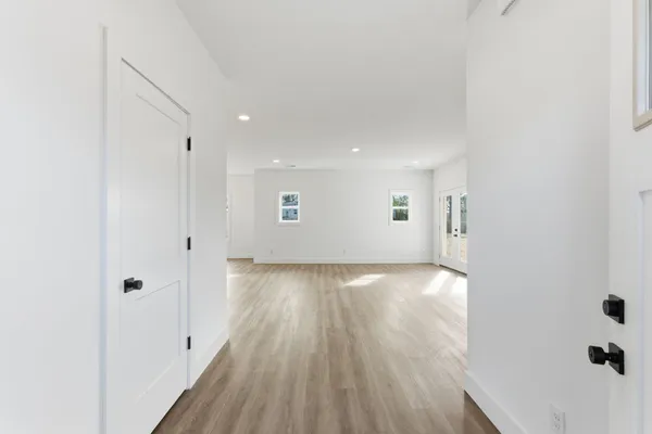 a view of a big room with wooden floor and windows