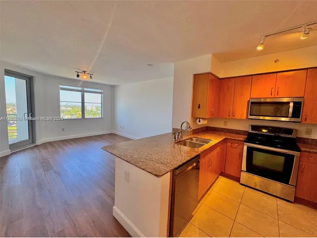 a kitchen with stainless steel appliances granite countertop a sink a microwave a stove and refrigerator