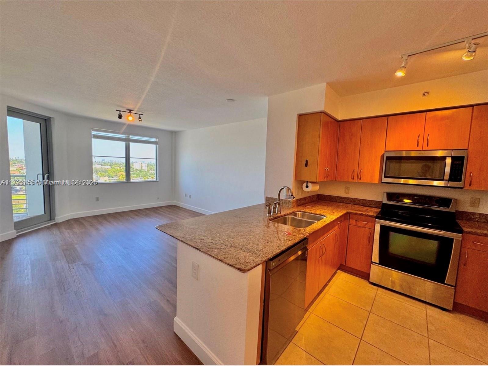 1830 Radius Drive, Unit 810 Hollywood, FL 33020 - Photo 21 of 26 a kitchen with stainless steel appliances granite countertop a stove a sink and a microwave