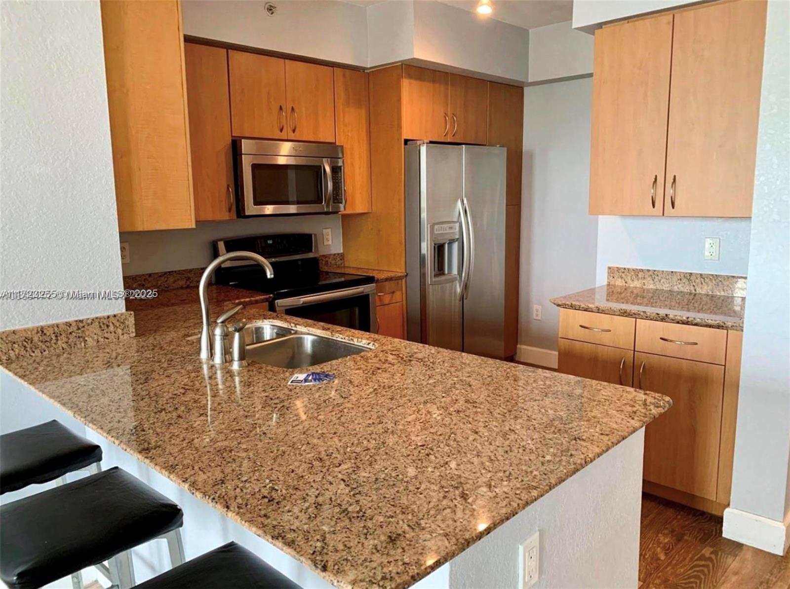 1830 Radius Drive, Unit 810 Hollywood, FL 33020 - Photo 22 of 26 a kitchen with stainless steel appliances granite countertop a sink a microwave a stove and refrigerator