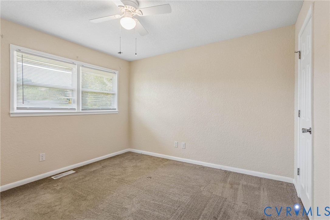 6 Barnes Court Hampton, VA 23664 - Photo 18 of 38 an empty room with a chandelier fan and windows