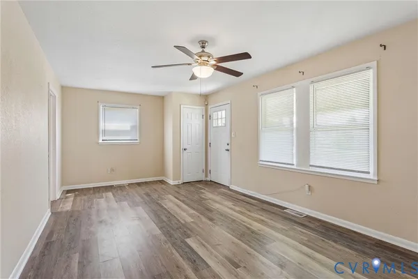 a view of a room with wooden floor and a window