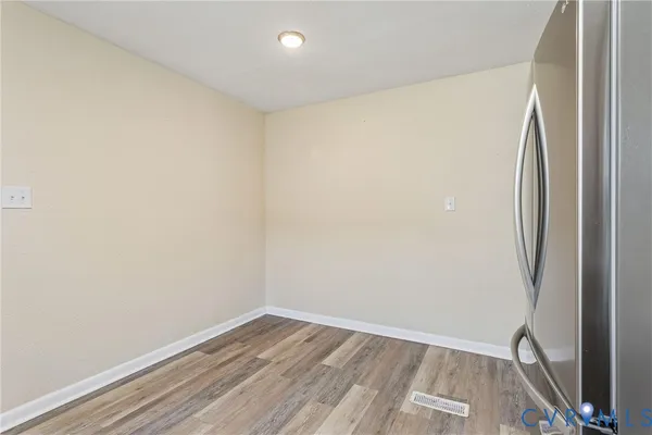 an empty room with a chandelier fan and windows