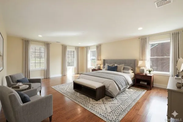 a spacious bedroom with a bed a couch and a window