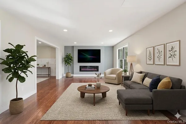 a living room with furniture a flat screen tv and a potted plant