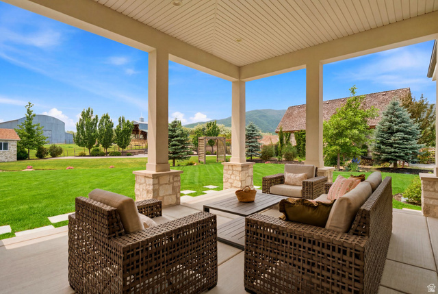 71 Farm Road Midway, UT 84049 - Photo 89 of 92 Expansive covered patio featuring a concrete surface, decorative columns with stone bases, and an open-gable ceiling