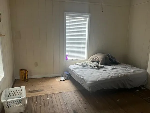 a bedroom with a bed and a window