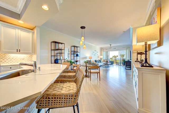 a living room with furniture a wooden floor and floor to ceiling window