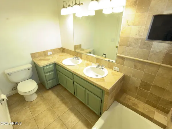 a bathroom with a sink double vanity mirror and a bathtub
