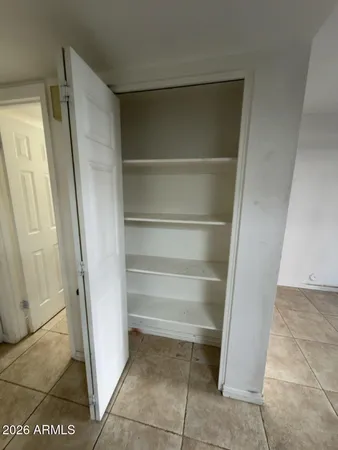 a view of walk in closet with empty racks