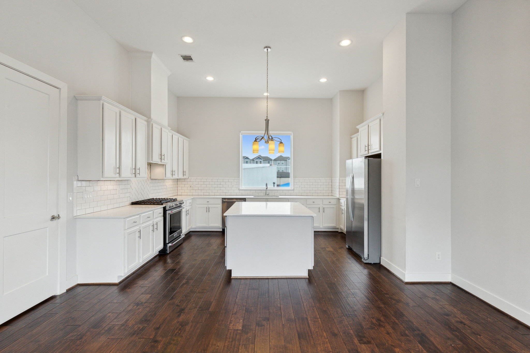 843 West 23rd Street, Unit B Houston, TX 77008 - Photo 16 of 34 a kitchen with a refrigerator a sink dishwasher a stove and white cabinets with wooden floor