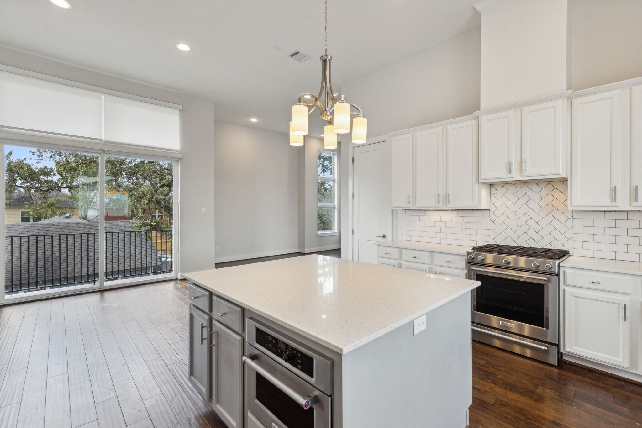 843 West 23rd Street, Unit B Houston, TX 77008 - Photo 19 of 34 a kitchen that has a microwave a stove and a wooden floor