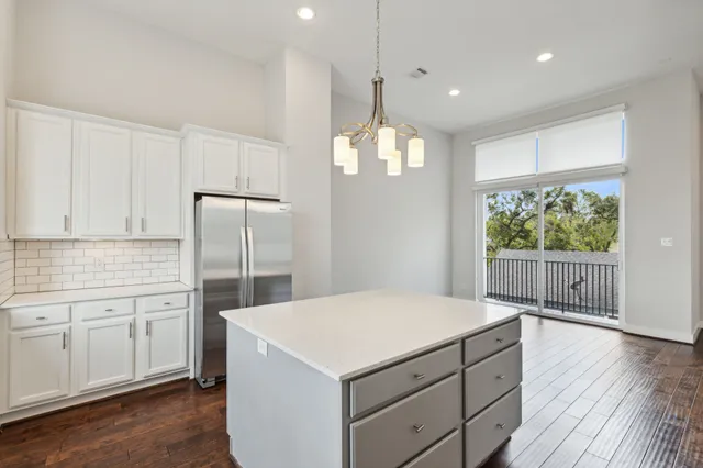 a kitchen with kitchen island white cabinets and wooden floor