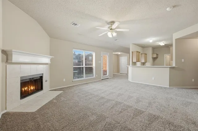 a view of an empty room with a fireplace and a window