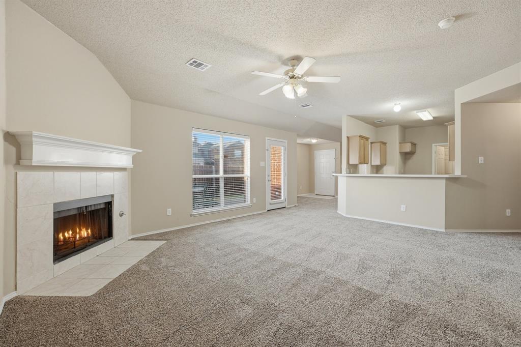 1410 Deville Circle Garland, TX 75043 - Photo 3 of 11 a view of an empty room with a fireplace and a window