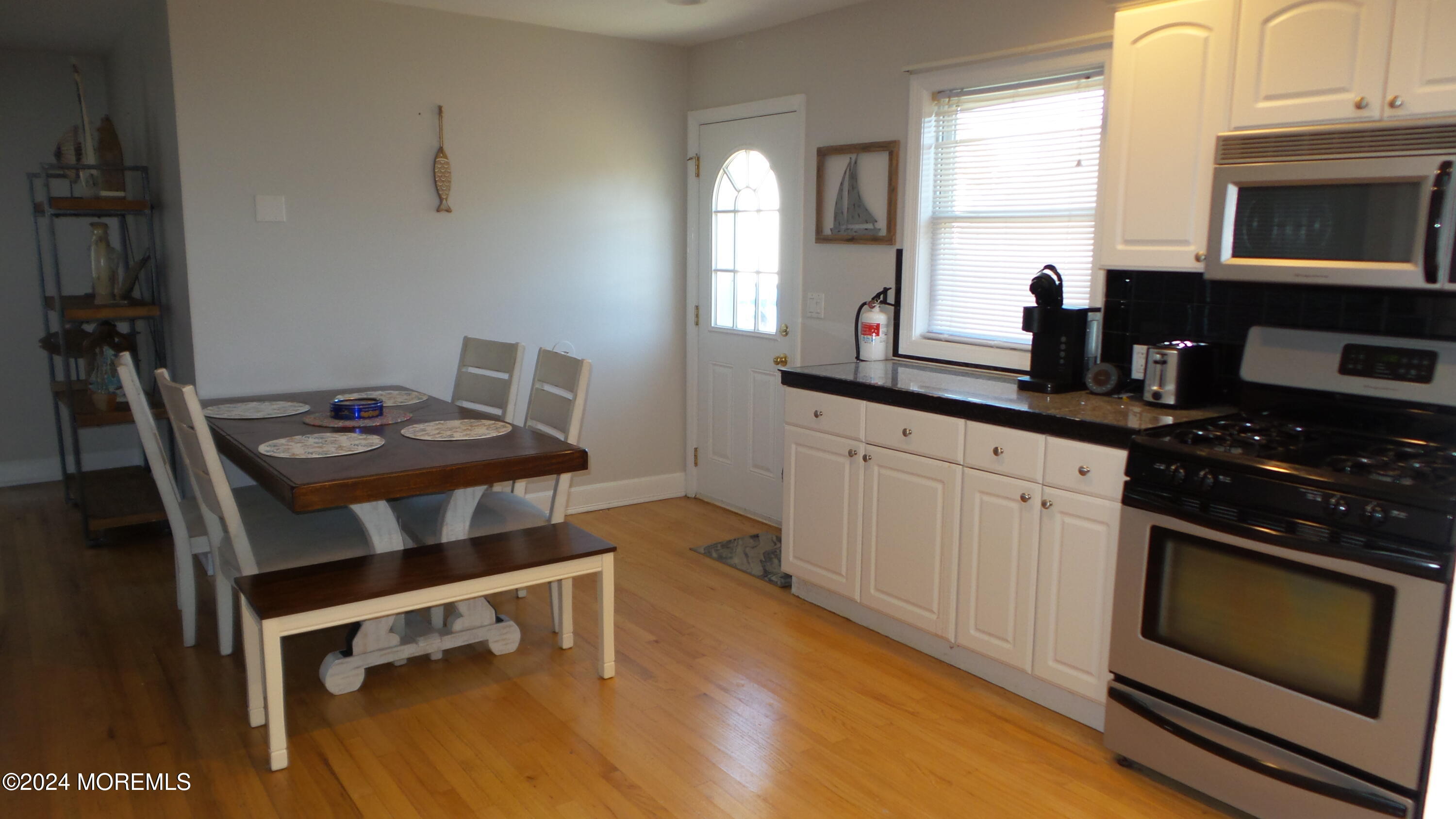 1502 Ivy Road Point Pleasant, NJ 08742 - Photo 8 of 24 a kitchen with stainless steel appliances a stove a sink cabinets and a dining table