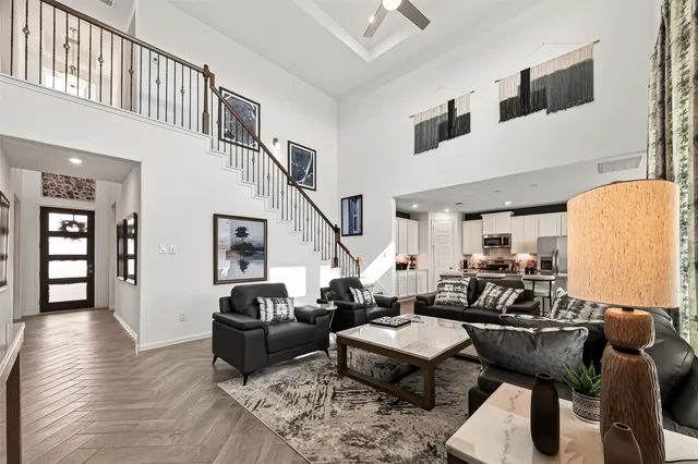 a kitchen with stainless steel appliances kitchen island granite countertop a sink a stove a refrigerator and white cabinets with wooden floor