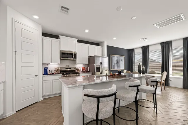 a kitchen with stainless steel appliances granite countertop a sink a stove a refrigerator and cabinets