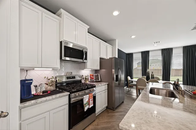 a kitchen with granite countertop a sink and living room view