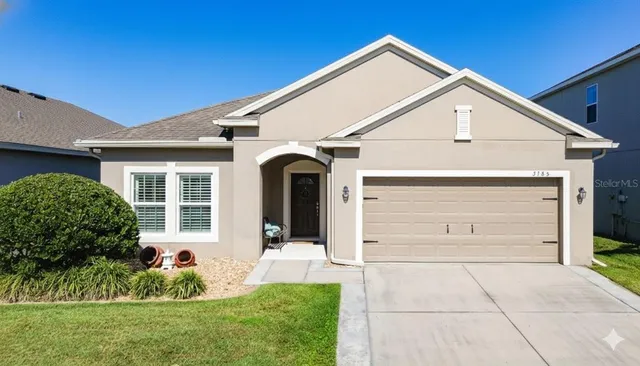 a view of a white house with a small yard and plants