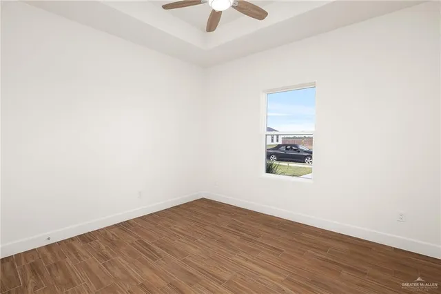 an empty room with a window and a ceiling fan