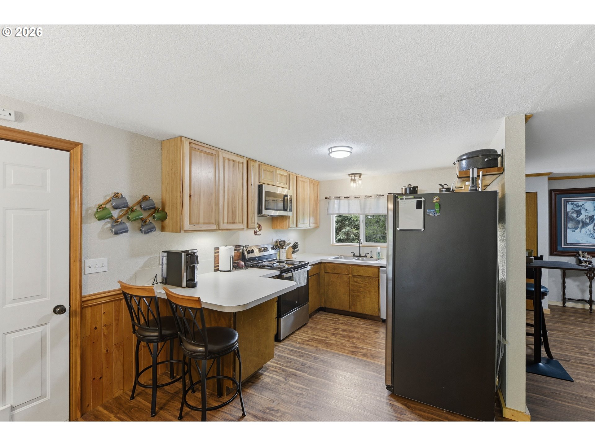 192 North Wood Ridge Road Coquille, OR 97423 - Photo 11 of 42 a kitchen with granite countertop a refrigerator a stove a sink dishwasher with a dining table and chairs