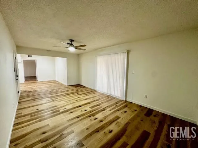 a view of a room has wooden floor and white walls