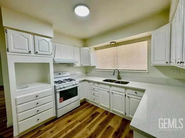 a kitchen with granite countertop white cabinets and stainless steel appliances