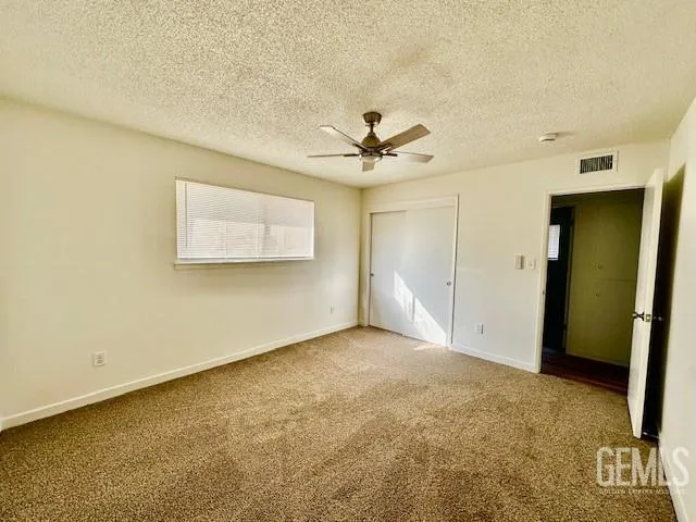 an empty room with a ceiling fan and a window
