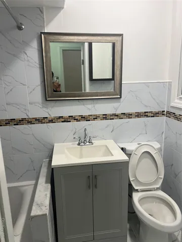 a bathroom with a toilet sink and mirror