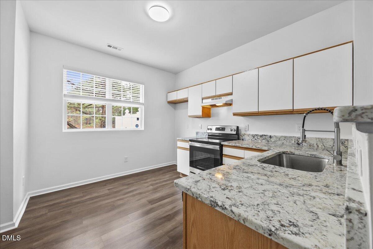 3831 Pin Oak Road Raleigh, NC 27604 - Photo 7 of 28 a kitchen with granite countertop a sink stove and cabinets