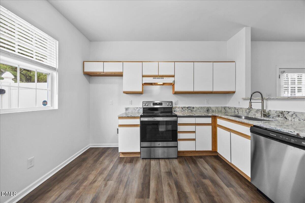 3831 Pin Oak Road Raleigh, NC 27604 - Photo 9 of 28 a kitchen with granite countertop white cabinets and white appliances