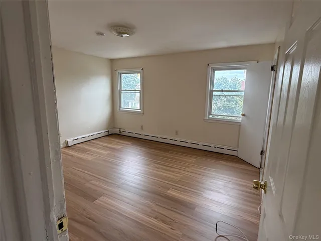 a view of a room with wooden floor and window