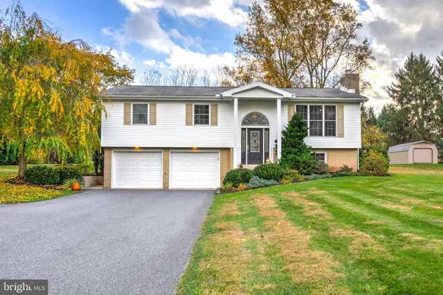 a front view of house with yard and trees