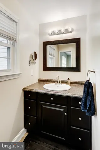 a bathroom with a sink vanity and mirror