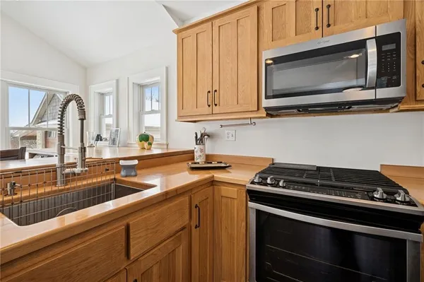 a kitchen with stainless steel appliances a stove microwave and sink
