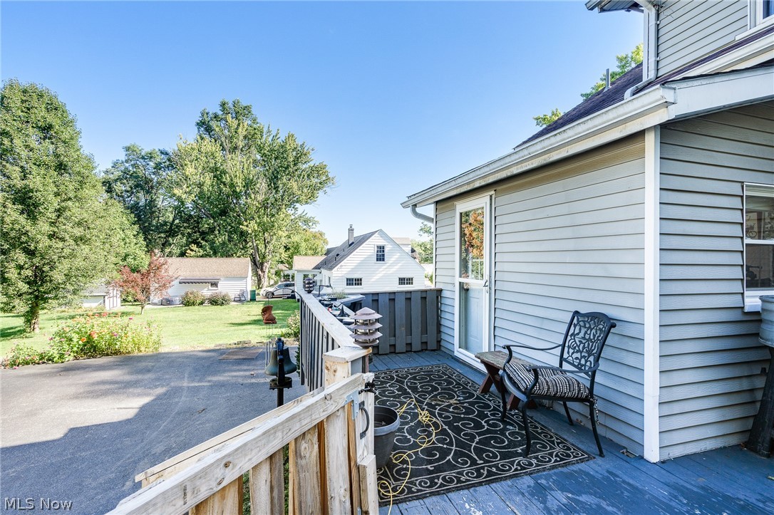 5840 Poland Struthers Road Youngstown, OH 44514 - Photo 21 of 50 Exterior siding with a window and a glass-paneled door opening onto a wooden deck with a wooden railing