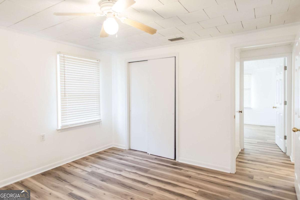 1329 Gorman Road Waycross, GA 31503 - Photo 15 of 23 a view of an empty room with wooden floor and a window