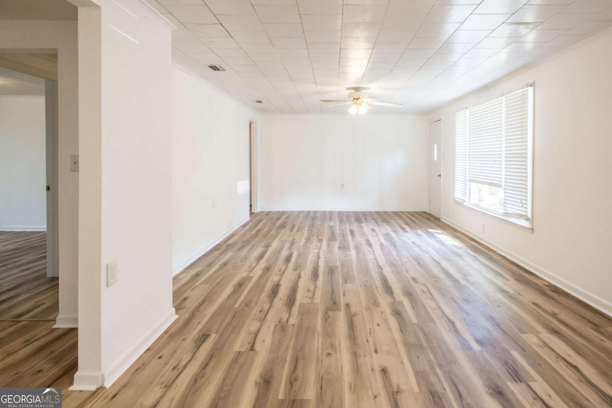 1329 Gorman Road Waycross, GA 31503 - Photo 4 of 23 a view of empty room with wooden floor and fan