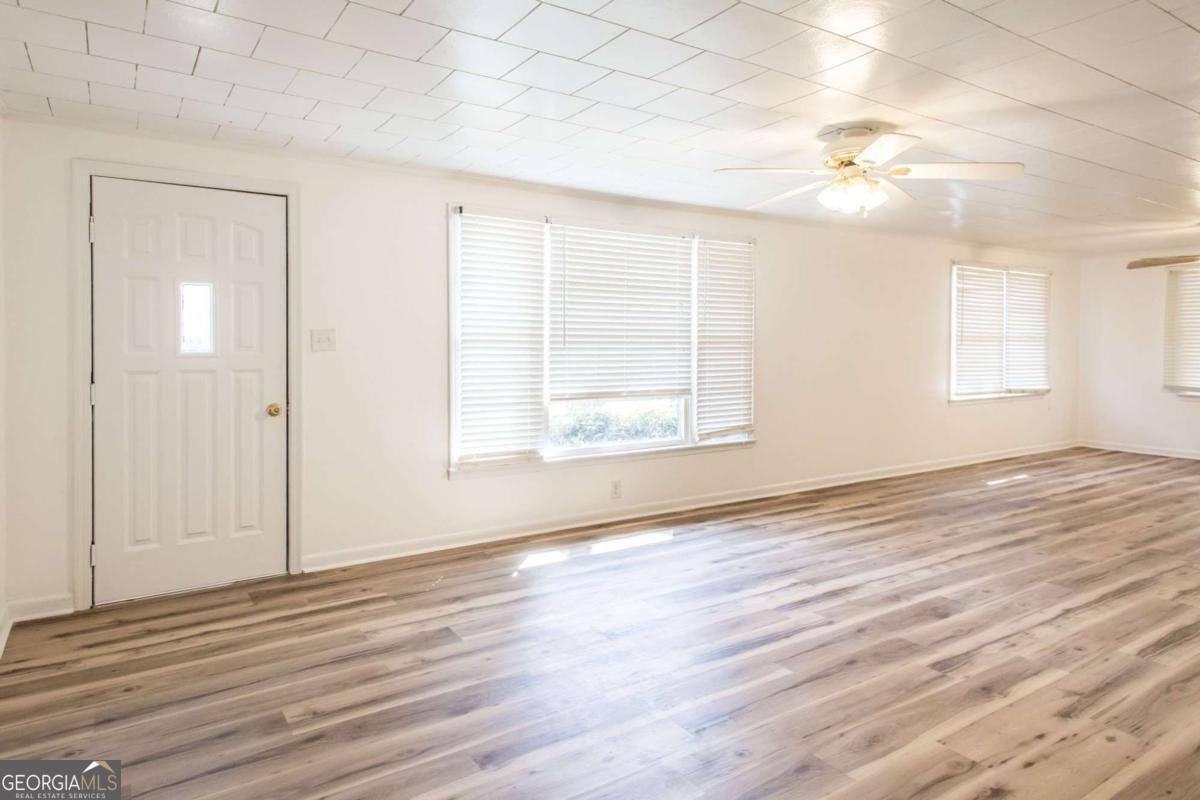 1329 Gorman Road Waycross, GA 31503 - Photo 5 of 23 an empty room with wooden floor and windows