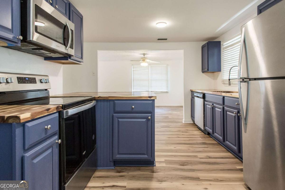 1329 Gorman Road Waycross, GA 31503 - Photo 6 of 23 a kitchen with stainless steel appliances granite countertop a refrigerator and a stove top oven