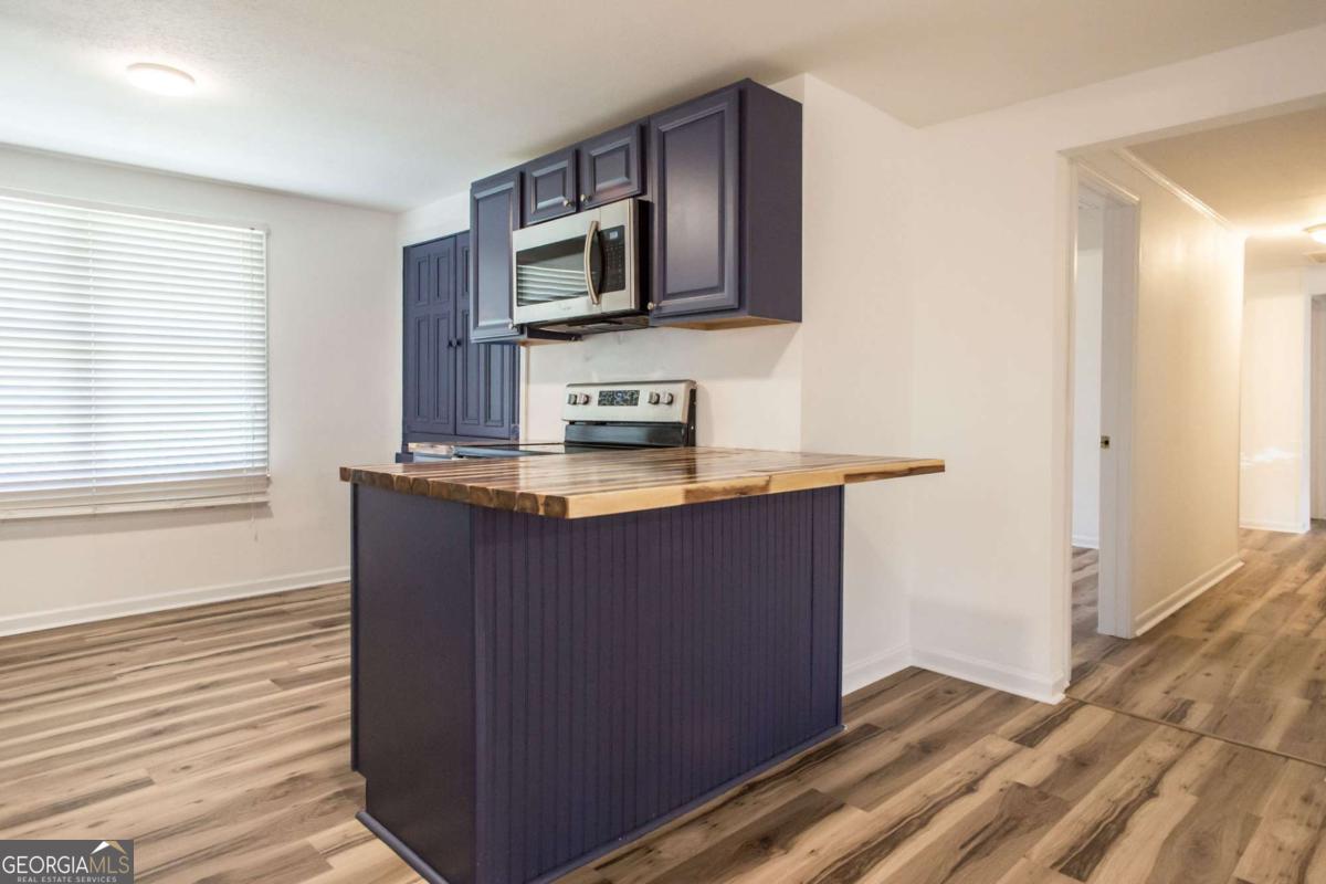 1329 Gorman Road Waycross, GA 31503 - Photo 8 of 23 a kitchen with stainless steel appliances granite countertop a stove a sink and a microwave