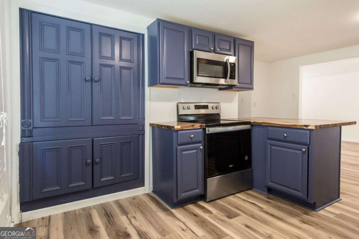 1329 Gorman Road Waycross, GA 31503 - Photo 9 of 23 a kitchen with granite countertop wooden cabinets and stainless steel appliances