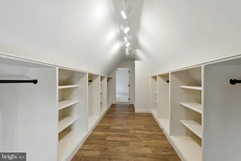 a view of a hallway with wooden floor and closet