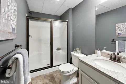 a bathroom with a granite countertop sink toilet and shower