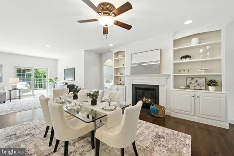 a dining room with furniture a fireplace and wooden floor
