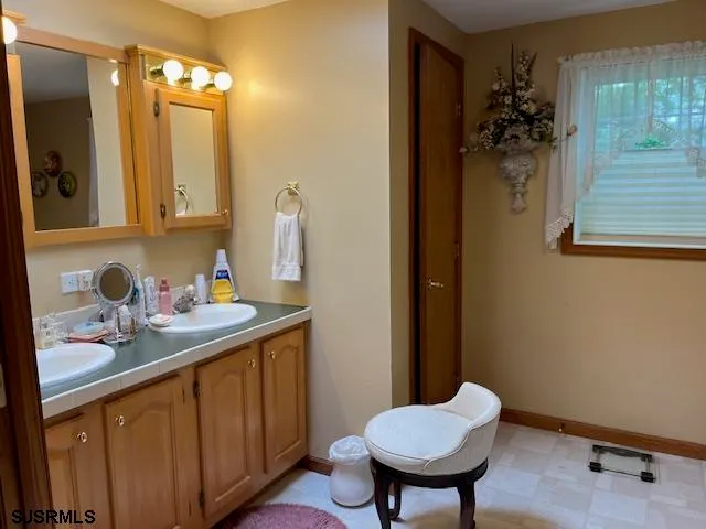 a bathroom with a granite countertop sink and a mirror